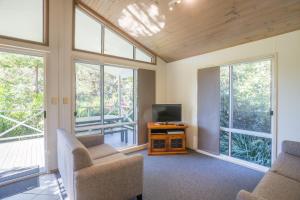 a living room with two chairs and a television at Fingal Bay Holiday Park in Fingal Bay