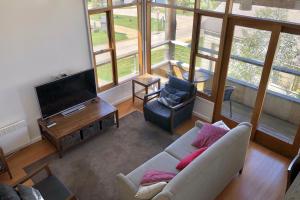 a living room with a couch and a tv at Triggerplant 3 in Dinner Plain