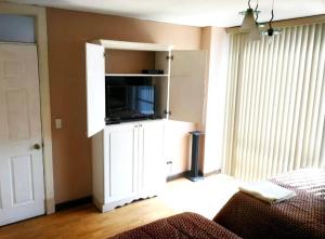 uma sala de estar com um armário branco com uma televisão em Apartamento 505 Cortijo Reforma zona 9 em Guatemala