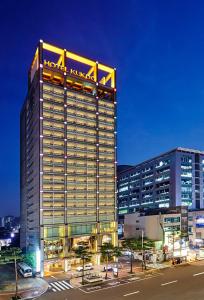 首爾的住宿－Hotel Kukdo，一座高大的建筑,上面有一座汉字酒店标志