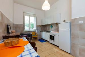 cocina con mesa y nevera blanca en Casa De Luca - appartamento con 3 camere 2 bagni e cucina in centro a Ceraso - fino ad 8 persone, en Ceraso