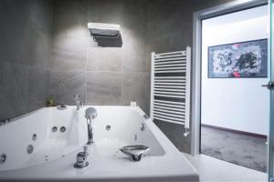 a bathroom with a bathtub, sink and mirror at Best Western Premier Natalija Residence in Belgrade