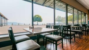 a restaurant with tables and chairs and a large window at Best Western Plus Silverdale Beach Hotel in Silverdale