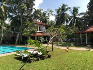 a resort with a swimming pool and a house at Villa 45 - Balapitiya in Balapitiya