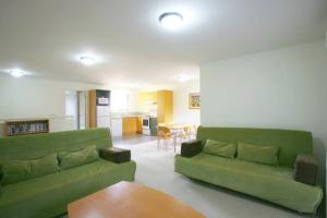 a living room with a green couch and a table at Noosa Holiday Accommodation in Noosaville