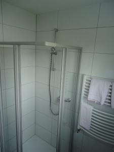 uma casa de banho com um chuveiro e uma porta de vidro em Centralhotel Ratingen em Ratingen