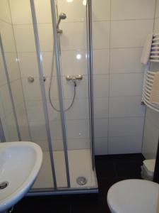 ein Bad mit einer Dusche und einem Waschbecken in der Unterkunft Centralhotel Ratingen in Ratingen