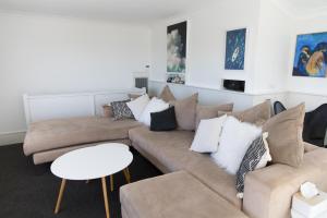 ein Wohnzimmer mit zwei Sofas und einem Tisch in der Unterkunft White Beach Cottage in Lake Cathie