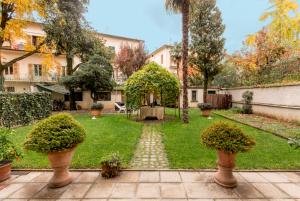 a garden with potted plants in a yard at Gourmet B&B Villa Landucci in Florence