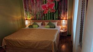 een slaapkamer met een bed met een bloemschilderij aan de muur bij Ahorn Hotel in Cottbus