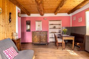 sala de estar con mesa y pared de color rosa en Agriturismo Da Attilio, en Cannobio