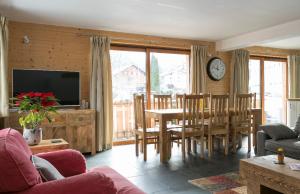 a living room with a table and a dining room at Chalet Marmotte 2 in Morzine