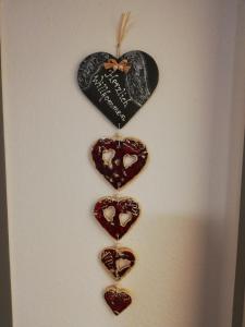 three hearts hanging on a wall with a heart plaque at Schmaranzer in Bad Ischl