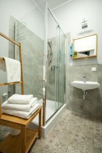 ブィドゴシュチュにあるDream Team Pomorskaのバスルーム(ガラス張りのシャワー、シンク付)