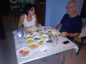米欣塔勒的住宿－Rock Villa Relax City Home，坐在餐桌旁吃饭的男人和女人