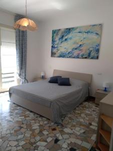 a bedroom with a bed and a painting on the wall at Stunning Aptm in Villa in Monterosso al Mare