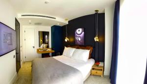 Una habitación de hotel con una cama grande y un televisor. en Maroon Tomtom, en Estambul