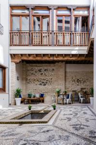 an outdoor patio with a pool and a balcony at Casas del Albaicín in Granada