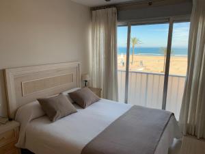 a bedroom with a bed and a view of the beach at BEACH I in Gandía +31 photos