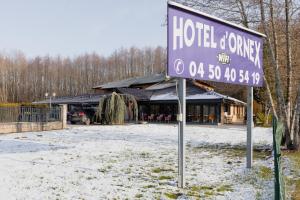 a sign in the snow in front of a building at Motel D'ornex in Ornex
