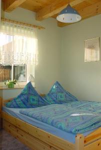 ein Bett mit blauer Decke in einem Schlafzimmer in der Unterkunft Urlaub im ehemaligen Kapitänshaus in Dierhagen