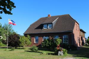 ein Haus mit einer Flagge im Hof in der Unterkunft Urlaub im ehemaligen Kapitänshaus in Dierhagen