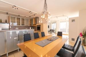 a kitchen and dining room with a large wooden table at Ski-n-Lake - The Alps View Apartment in Zell am See