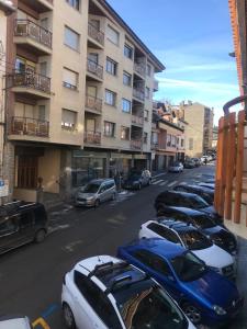 uma fila de carros estacionados numa rua da cidade em Apartamento Turístico Puigcerdá Correos em Puigcerdà