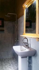 a bathroom with a white sink and a mirror at Saffron Eco Cottage in Ella