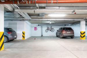 a parking garage with two cars parked in it at Apartamenty Stella Baltic by Renters in Świnoujście