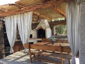 a wooden patio with a table and a bench at Il Giardino di Daniela Apartments in San Teodoro