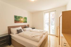 a bed in a room with a large window at Ski-n-Lake - The Alps View Apartment in Zell am See