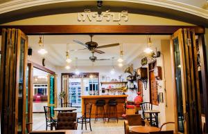 un restaurante con un bar con mesas y sillas en Baan Kiang Wang, en Phetchaburi