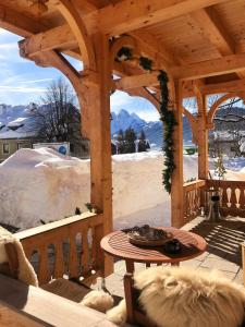 a wooden gazebo with a table on a patio at Der Ulmenhof in Gosau
