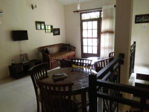 a dining room with a table and chairs and a television at Abha Villa in Galle