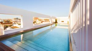 a swimming pool on the roof of a building at Hotel Mercer Sevilla 5 GL in Seville