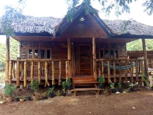 a wooden house with a thatched roof at Travis Post Homestay in Siquijor