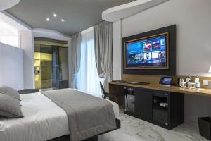 a bedroom with a bed and a desk with a television at Borgo San Barbato in Lavello