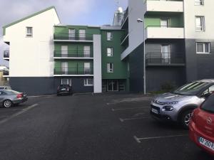 a parking lot with cars parked in front of a building at Terres de France Brest in Brest
