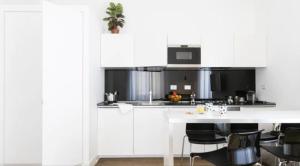een keuken met witte kasten en een tafel met stoelen bij App Leoncino Design Apartment in Rome in Rome