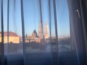 Una vista del horizonte de una ciudad desde una ventana en Dave Apartman, en Szeged