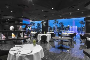 Borgo San Barbato Resort Spa & Golf في Lavello: مطعم بطاولات بيضاء وكراسي وإطلالة