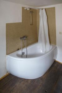 a white bath tub with a shower in a bathroom at Nengshof Ferienhaus Gänseblümchen in Wißmannsdorf