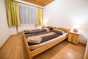 1 dormitorio con cama grande de madera y ventana en Hotel Krpáčovo en Krpacovo