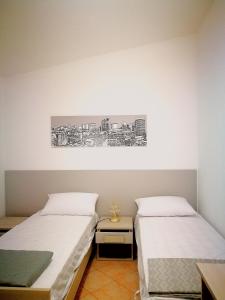 a bedroom with two beds and a painting on the wall at Teresa's apartments in Santa Domenica