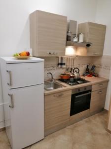 een keuken met een witte koelkast en een wastafel bij Ad un passo dal Duomo "2" in Napels