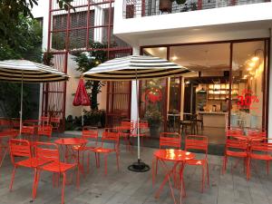 dos sombrillas, mesas y sillas frente a un restaurante en LaRose Cafe I Bed & Breakfast, en Quy Nhon