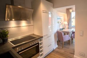 a kitchen with a stove top oven next to a table at Abendsonne in Westerland