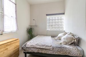 1 dormitorio con cama con almohadas y ventana en Studios entre le Pont d' Avignon et le Palais des Papes, en Aviñón