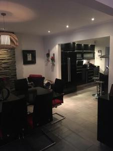 a living room with a table and chairs and a kitchen at Invercreran Lodge Luxury Bed & Breakfast in Appin